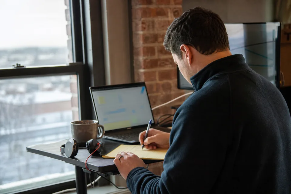 Sales operations manager checking cold email plan limits on a laptop beside a notepad of mailbox counts